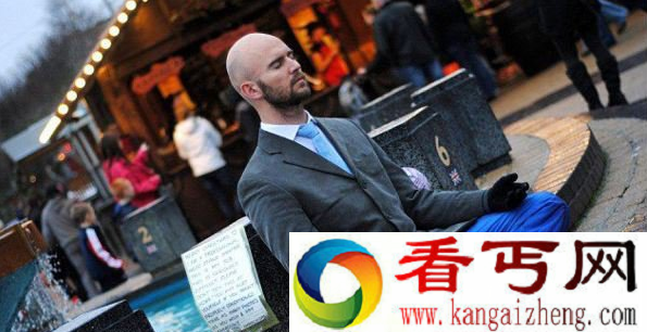 英国艺术家街头表演倒立 将头塞进水桶