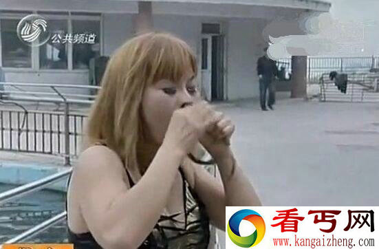 山东烟台景区内一美女正在进行吃活蛇表演